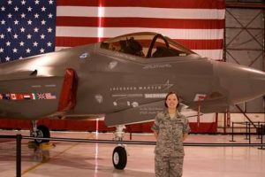 EE Ph.D. student, Katherine Pratt, is pictured with a F-35 Joint Strike Fighter. Pratt is a U.S. Air Force Veteran. Credit: Katherine Pratt via KUOW.